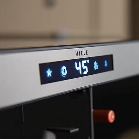 Miele wine cooler repair Sacramento specialist adjusting temperature controls, ensuring precise wine preservation.
